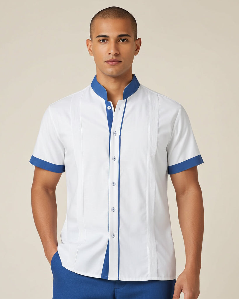 Man wearing a white guayabera shirt with blue accents on a beige background