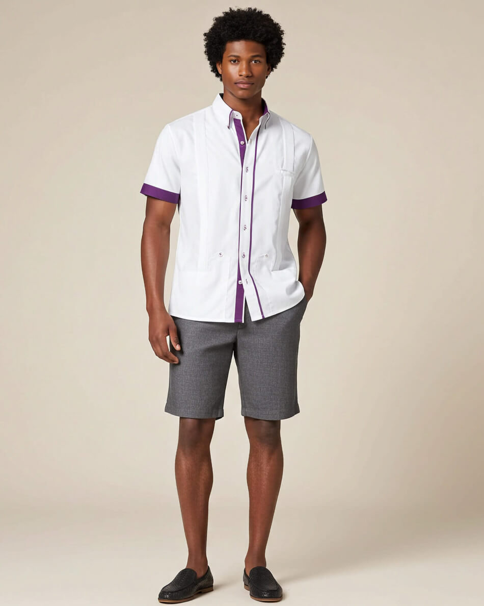 Man wearing a white guayabera shirt with purple accents and gray shorts on a beige background