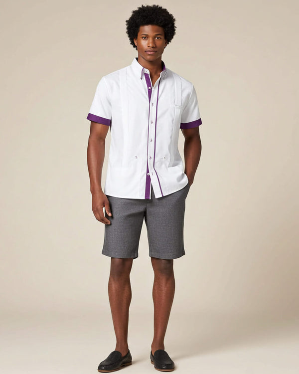 Man wearing a white guayabera shirt with purple accents and gray shorts on a beige background