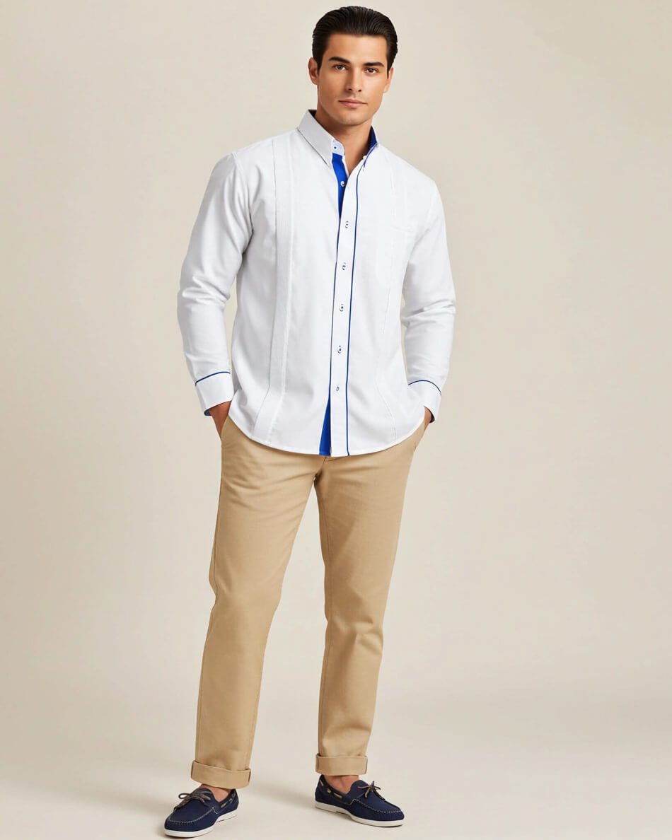 Man wearing a white guayabera shirt with long sleeves and beige pants on a plain background
