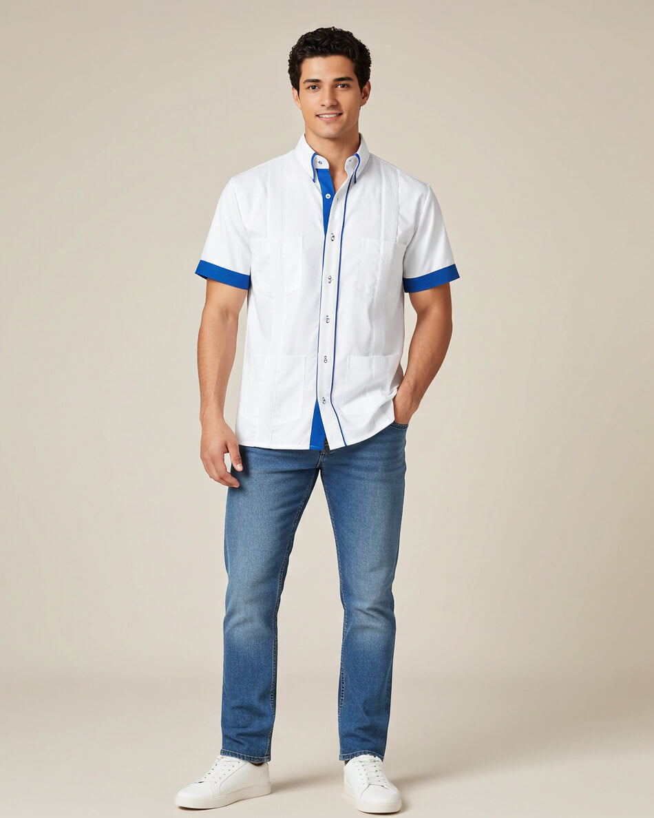 Man wearing a white guayabera shirt with blue accents and blue jeans on a beige background