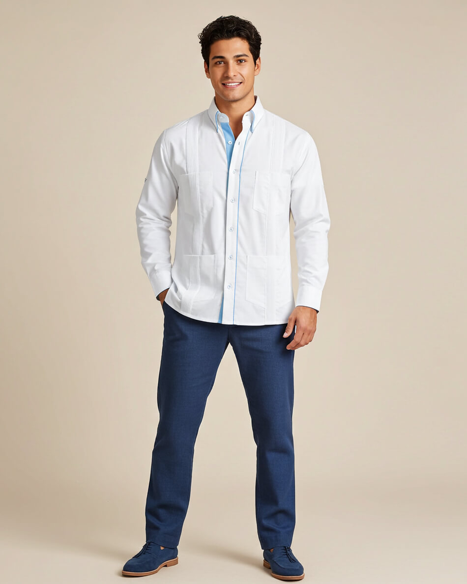 Man wearing a white long-sleeve guayabera shirt and blue pants on a beige background