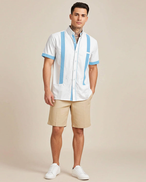 Man wearing a white guayabera shirt with blue accents and beige shorts on a beige background