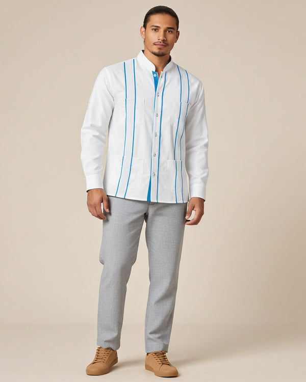 Man wearing a white guayabera shirt with turquoise stripes and gray pants on a beige background