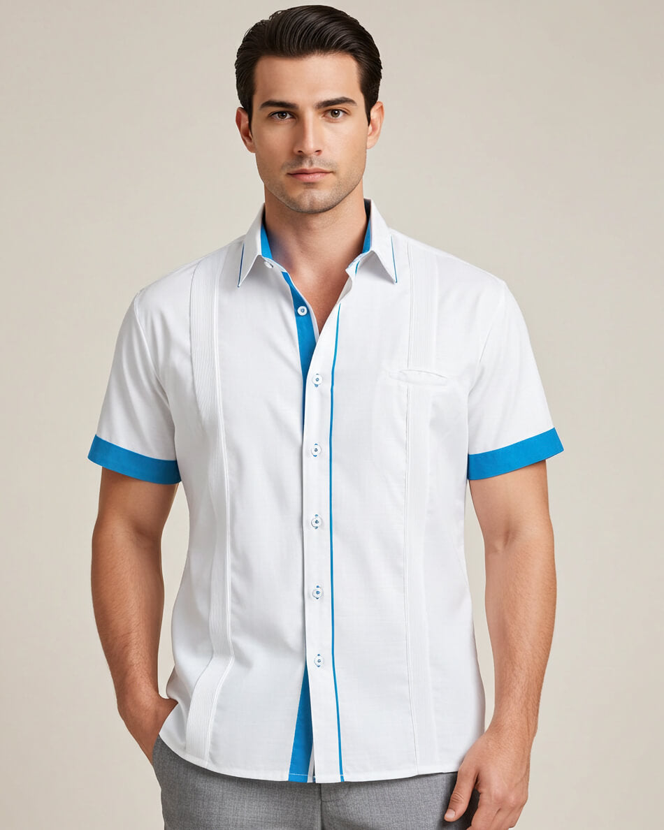 Man wearing a white guayabera shirt with turquoise accents on a beige background