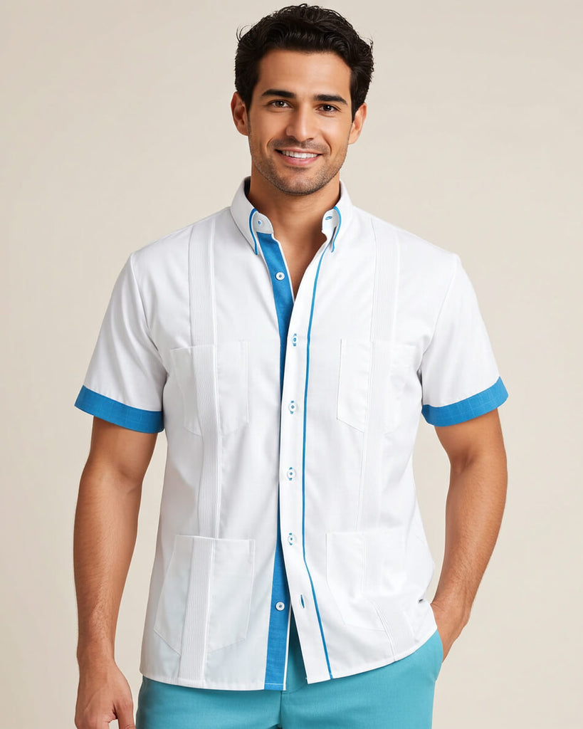 Man wearing a white short-sleeve guayabera shirt with turquoise accents on a beige background