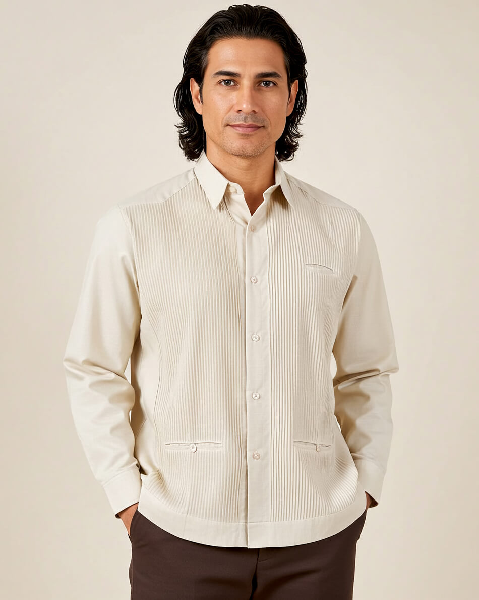 Man wearing a beige button-up guayabera shirt against a plain background