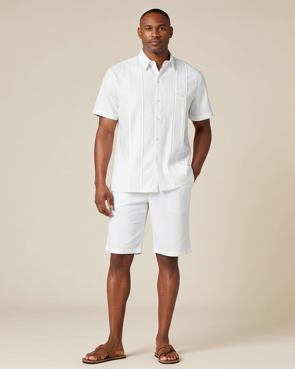 Man wearing a white guayabera short-sleeve shirt and shorts on a beige background