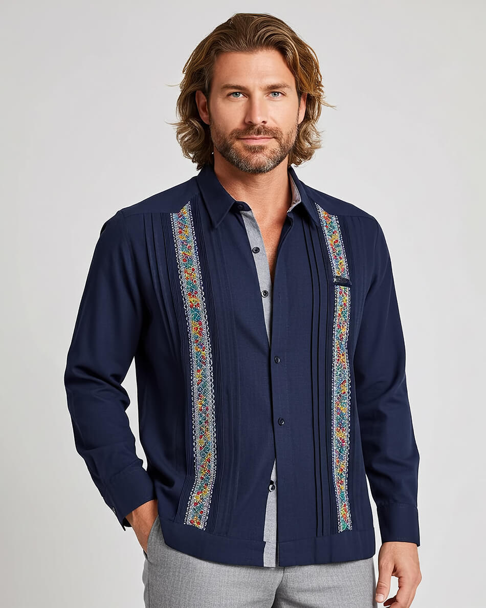 Man wearing a navy blue guayabera shirt with colorful embroidery on a light gray background