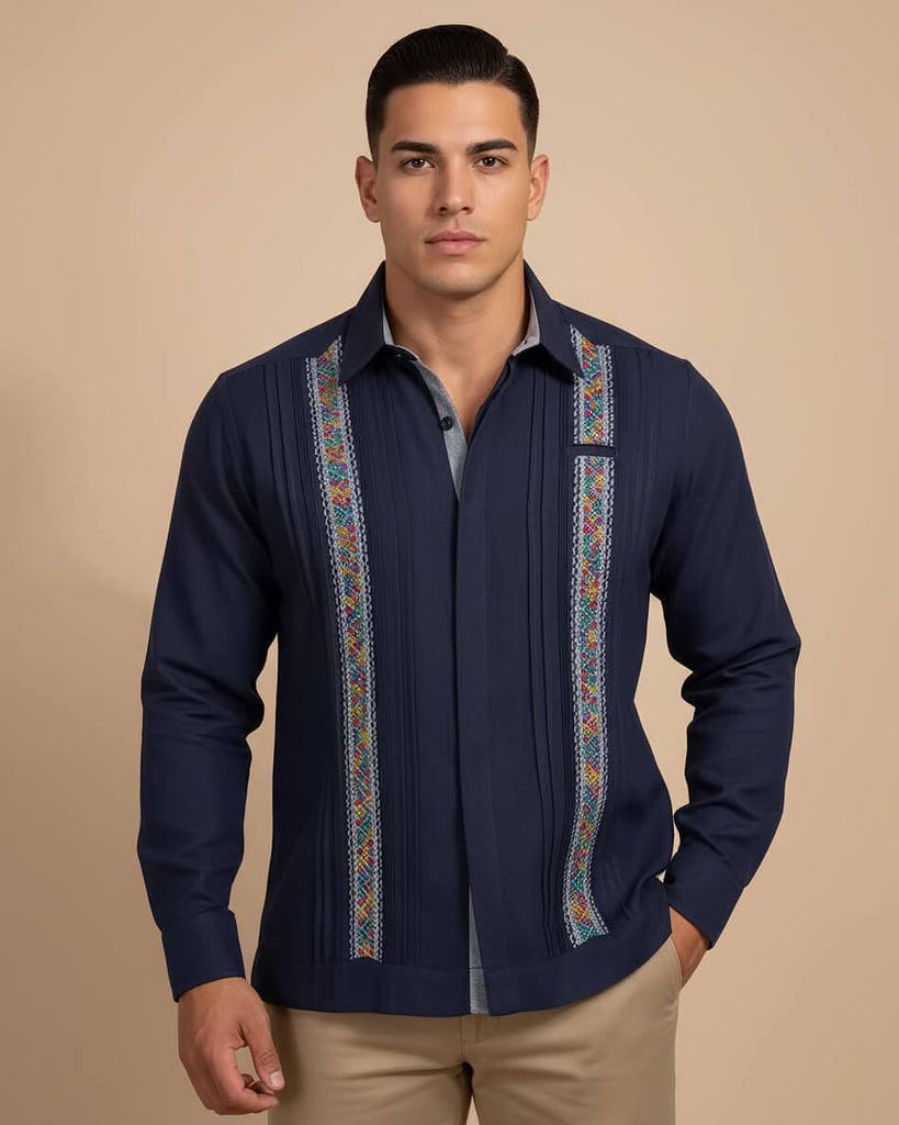 Man wearing a navy blue embroidered guayabera shirt on a beige background