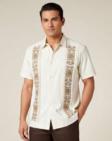 Man wearing a beige guayabera embroidered shirt against a beige background