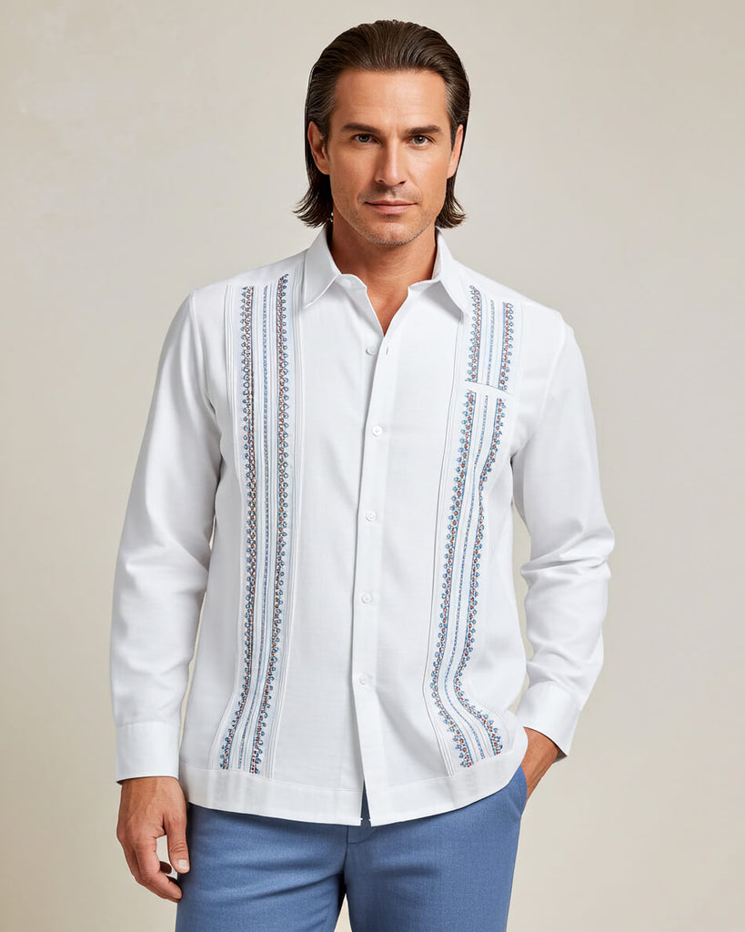 Man wearing a white guayabera embroidered shirt with blue pants on a beige background