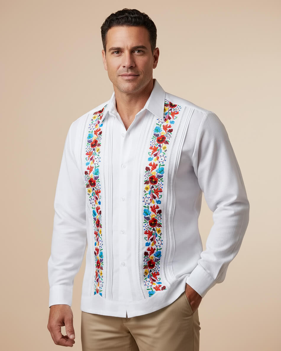 Man wearing a white guayabera shirt with colorful floral embroidery on a beige background